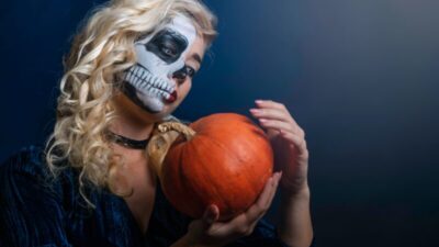 Woman with face paint with pumpkin